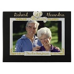 There is certainly a cause for celebration for a couple who reach fifty years of marriage! This lovely dark brown wood picture frame with silver and gold metal accents that will showcase their 4” x 6” photograph makes an amazing anniversary gift. This 50th wedding anniversary picture frame is personalized with their first names on either side of the heart-shaped 50th Anniversary charm and the notation, “True Love Lasts Forever” underneath. Frame measures 8.25" x.50" x 6.25". 
