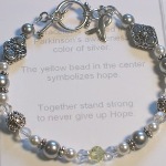The Parkinsons Awareness bracelet is designed in the assigned parkinson awareness color of silver. Swarovski crystals, pearls and bali silver is used to making this an elegant parkinson awareness symbol to help spread attention and support to Parkinsons Disease. The yellow bead in the center and the awareness charm helps symbolizes hope and awareness and serves as a reminder that you are not alone.