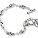 Our silver toned and pearl bracelet is a meaningful gift idea to give to someone very special. Heart Charm. Card reads: First you caught my eye, then you caught my heart. 