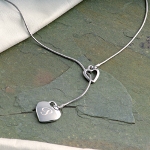 Find the designer lariat style necklace youve been looking for with our Personalized Double Heart Lariat Necklace. With its fashion forward look, this rhodium finished necklace features a hollow heart with a solid heart charm on a snake chain. Its the perfect combination of personalized style and fashionable appeal. So, whether youre looking for the perfect gift for a birthday girl or bridesmaid, this necklace is great for all occasions. Includes a free organza gift pouch.